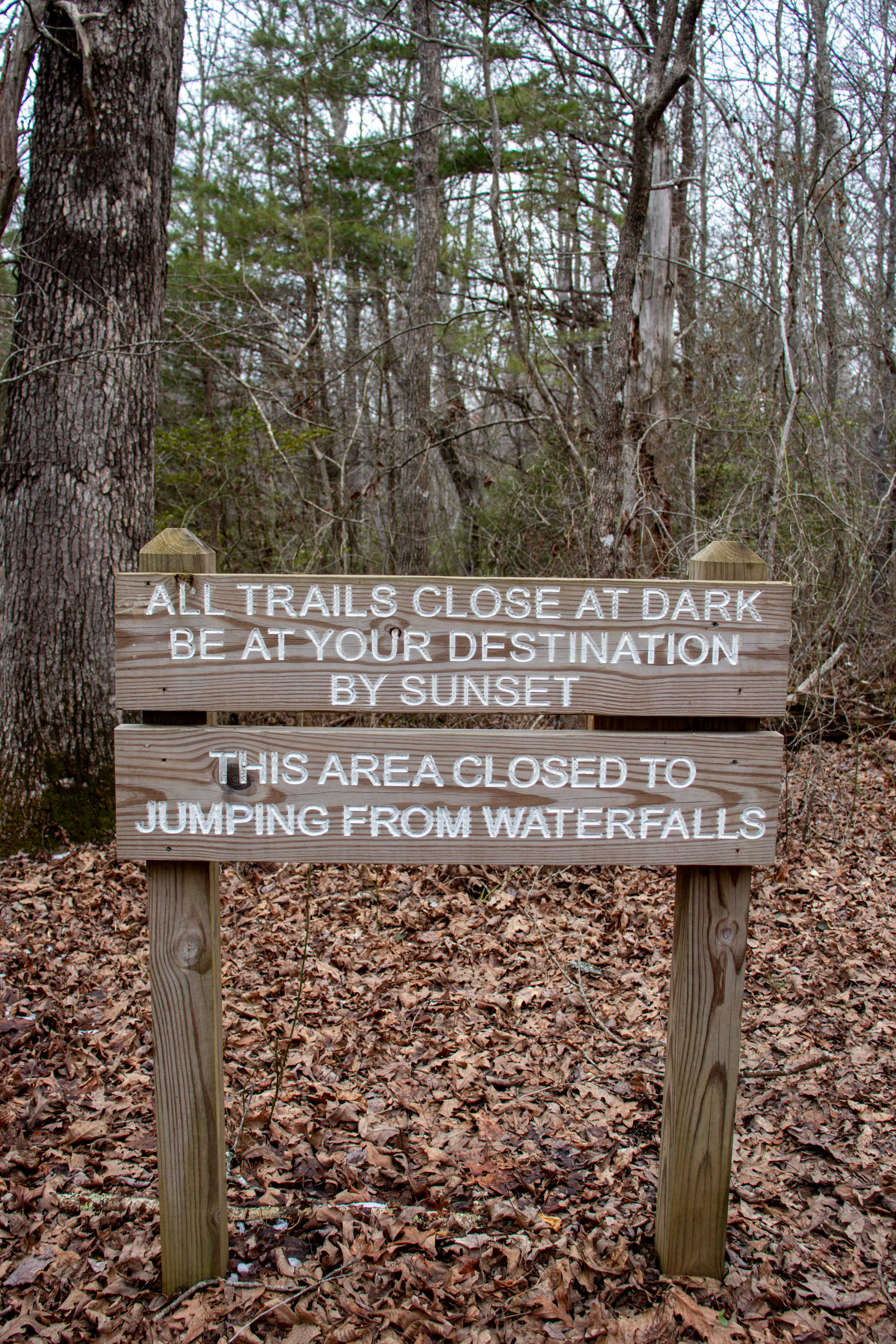 sign on trail "All trails close at dark. Be at your destination by sunset. This area closed to jumping from waterfalls."